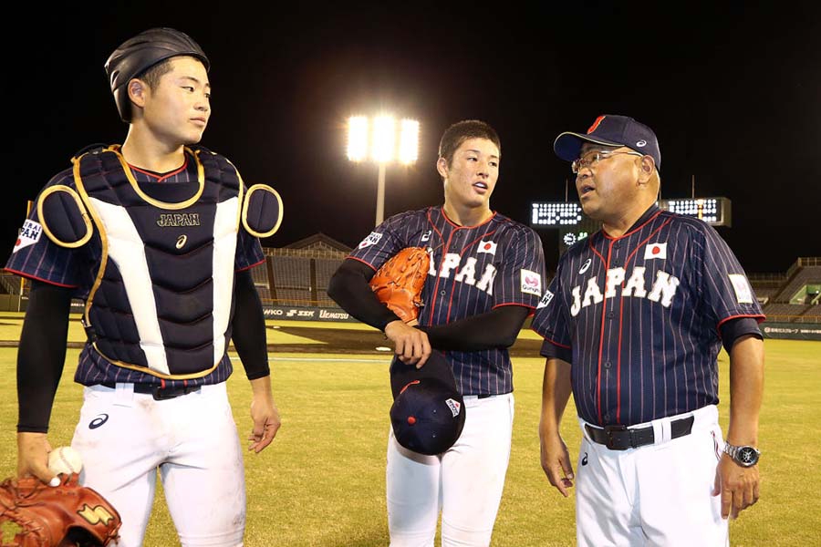 吉田・小泉のバッテリーと会話する侍ジャパンU-18代表・永田裕治監督（右端）【写真：Getty Images】