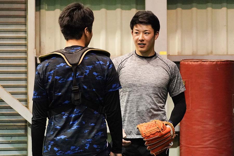 投球練習後に植村ブルペン捕手（左）と話す日本ハムのドラフト1位・吉田輝星【写真：荒川祐史】