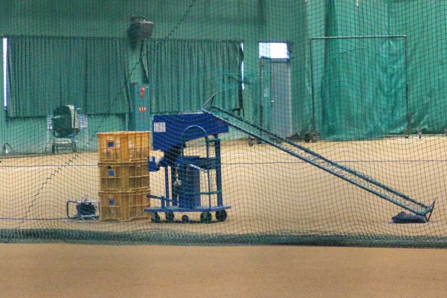 室内練習場に置かれたスローボールマシン【写真：安藤かなみ】