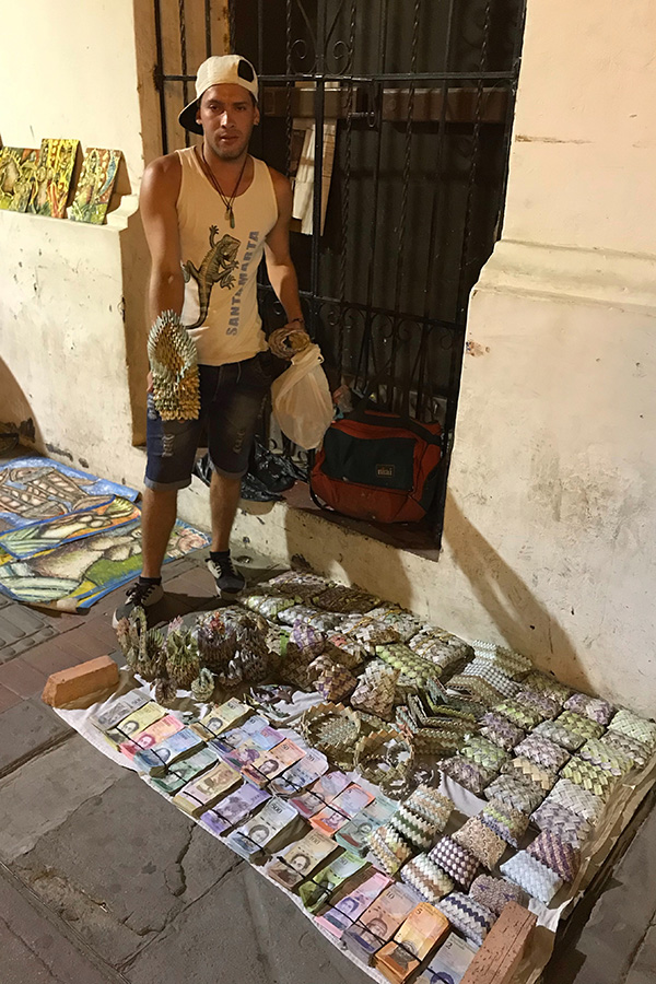 ベネズエラに近いコロンビアの街サンタマルタでは、ハイパーインフレで紙切れ同然になったベネズエラ紙幣で財布などをつくり、売っている避難民の姿があった【写真：福岡吉央】
