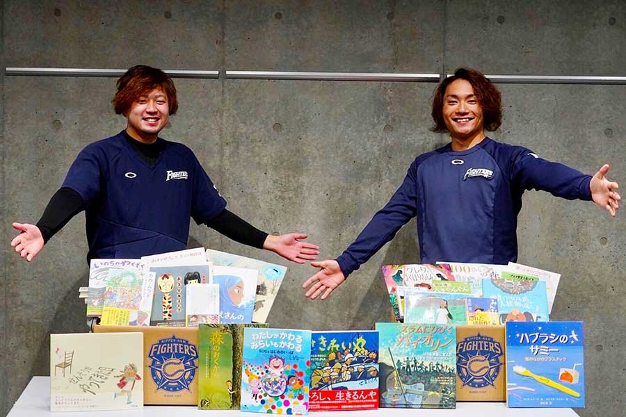 集まった書籍と笑顔で写真に納まる日本ハム・堀瑞輝（左）と伊藤大海【写真：球団提供】
