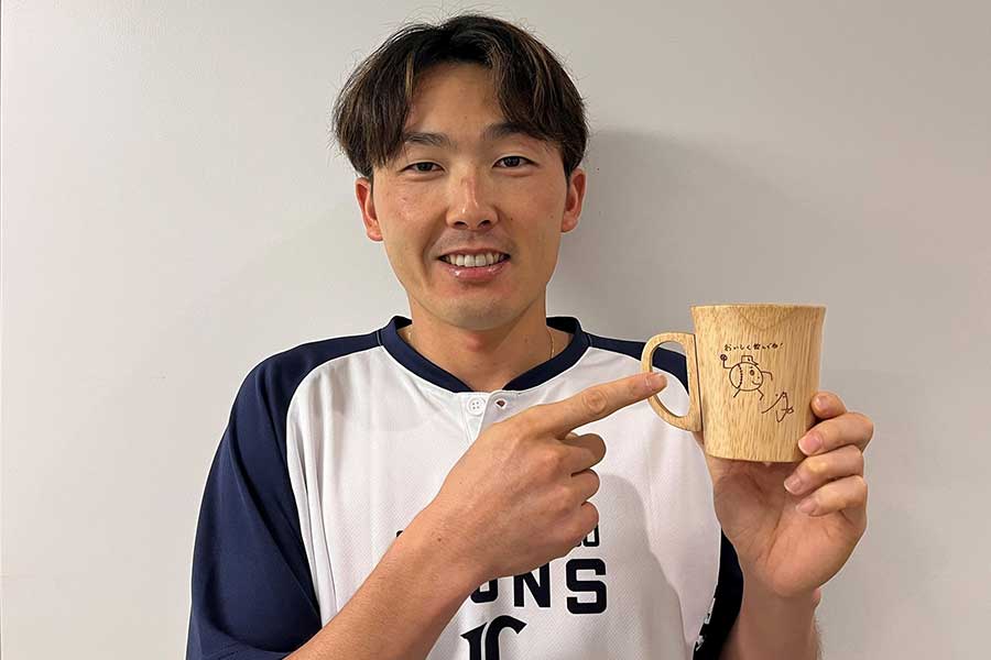 入会特典のマグカップを手に取る西武・源田壮亮【写真：球団提供】