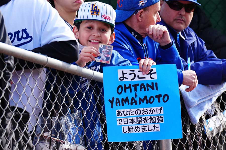 メッセージボードを掲げる少年【写真：荒川祐史】