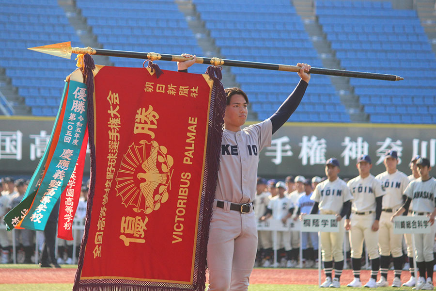 深紅の大優勝旗を掲げる加藤右悟主将【写真：大利実】