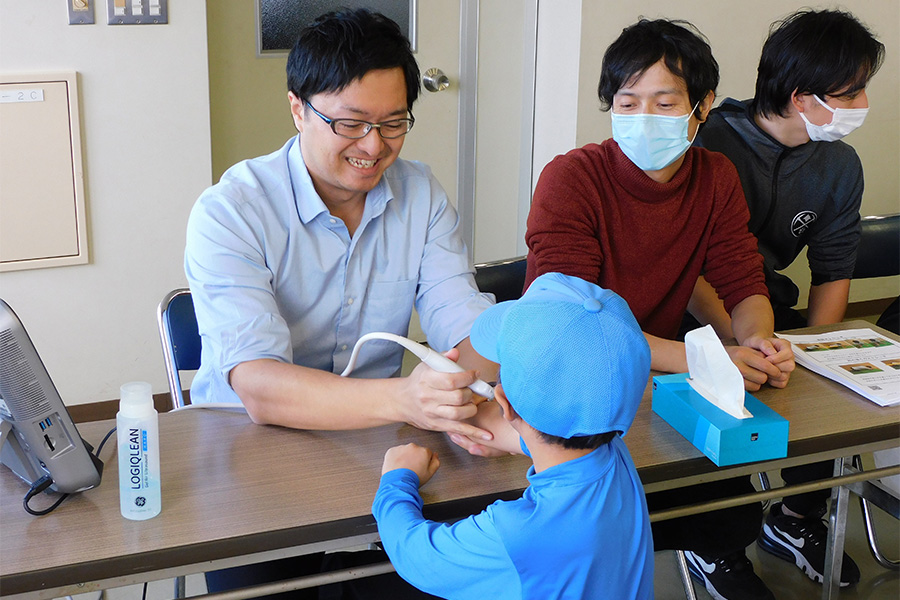 野球肘検診を行う山田唯一氏【写真：間淳】