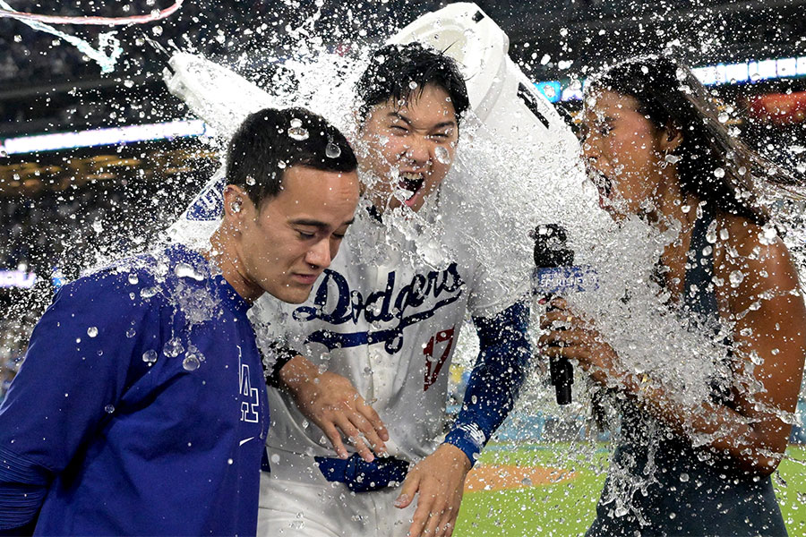 ウォーターシャワーを浴びるドジャース・大谷翔平（中央）とキルステン・ワトソンさん【写真：ロイター】