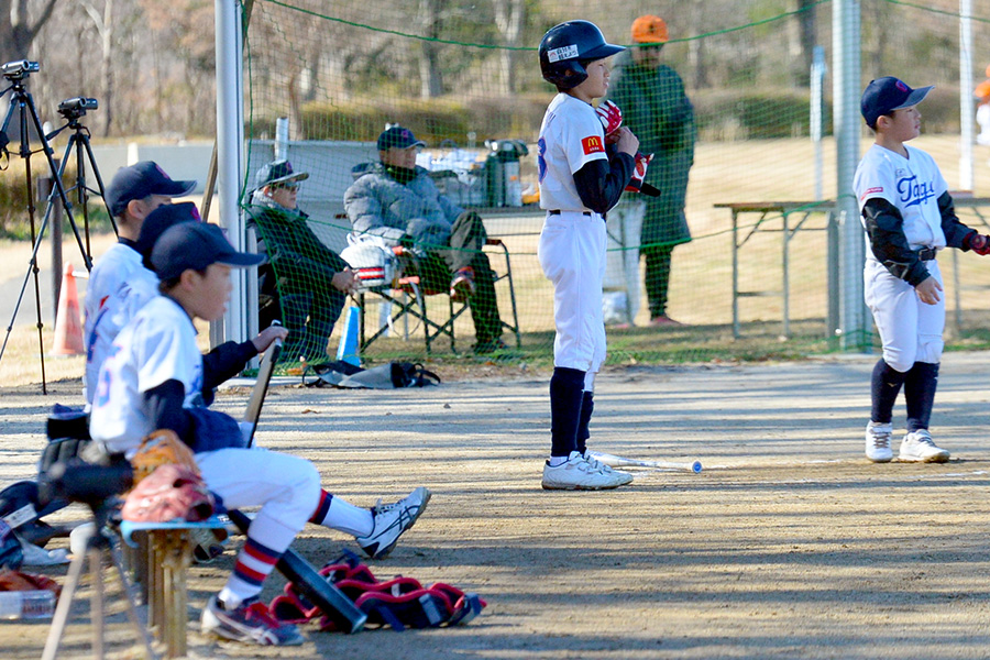 ネット裏で試合を静観する辻監督（奥）は「任せてガマンして待つ」【写真提供：フィールドフォース】