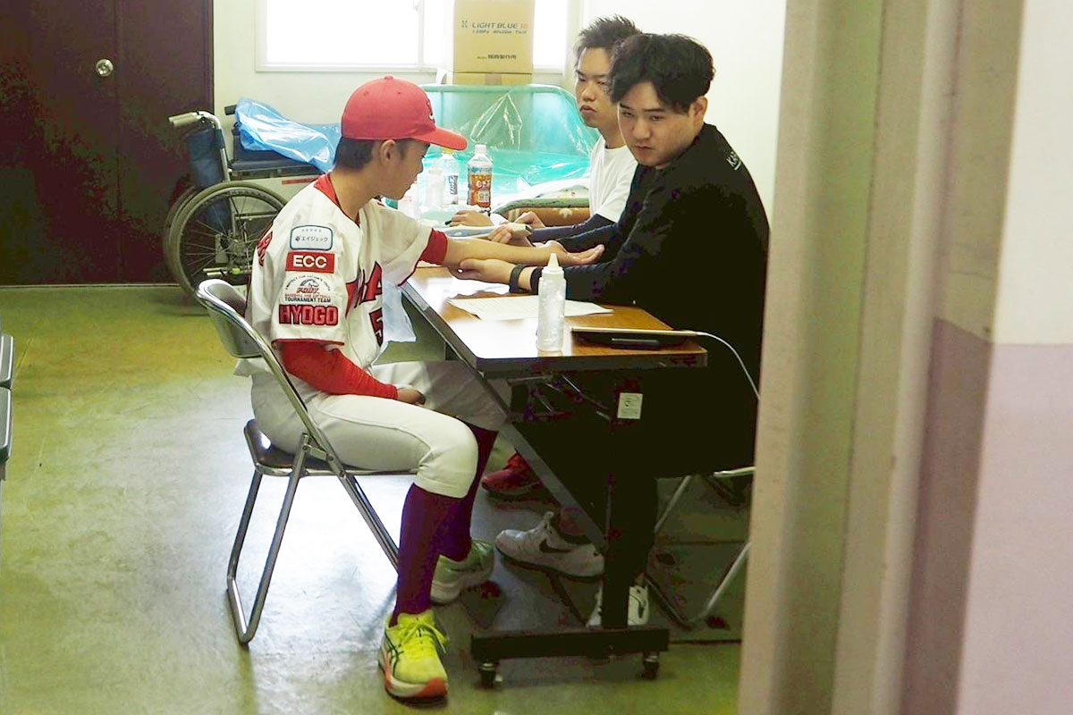 トレーナーと肘をチェックする様子【写真：関メディベースボール学院提供】