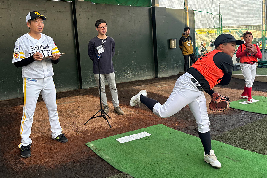 投球スピード計測を行う嘉弥真新也監督（左）【写真：球団提供】