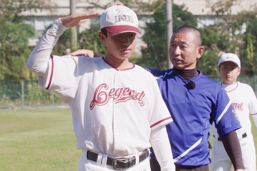 「敬礼ポーズ」を指導する塩多雅矢氏【写真：編集部】
