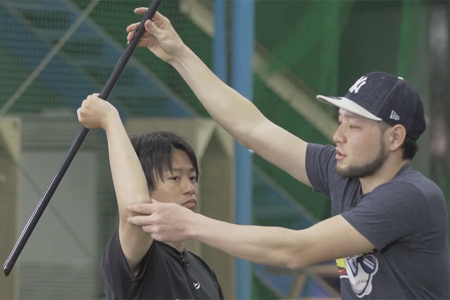 棒を使った投球ドリルを指導する菊池タクト氏（右）【写真：編集部】
