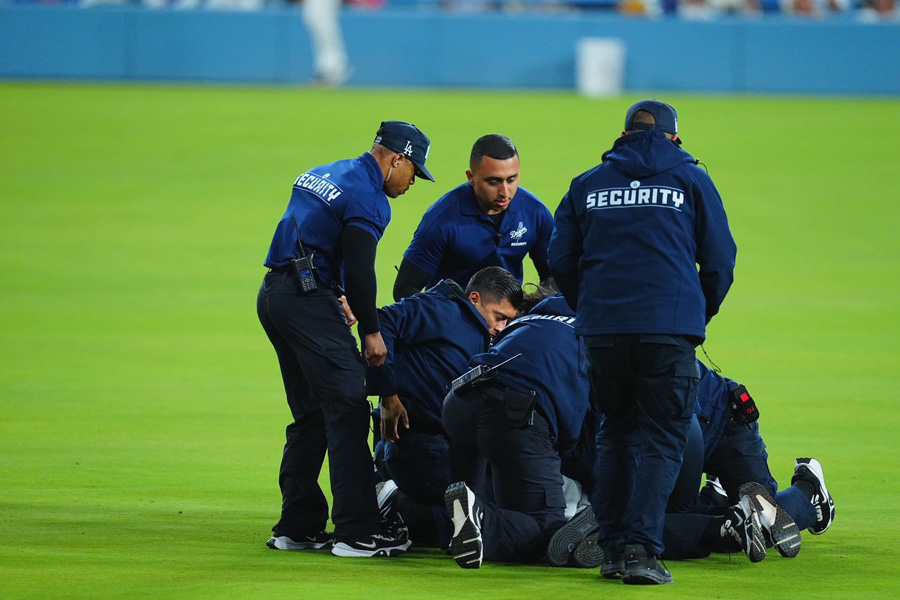 グラウンドに侵入したファンを取り押さえる警備員【写真：荒川祐史】