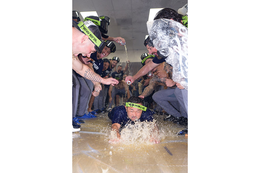 シャンパンファイト中にヘッドスライディングする中島陽介トレーナー【写真：ロイター】