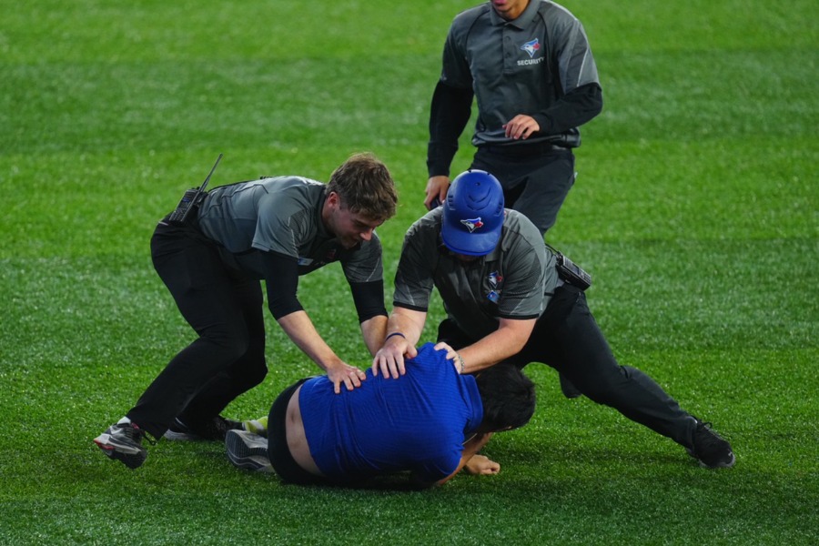 グラウンドに侵入したファンを取り押さえる警備員【写真：荒川祐史】