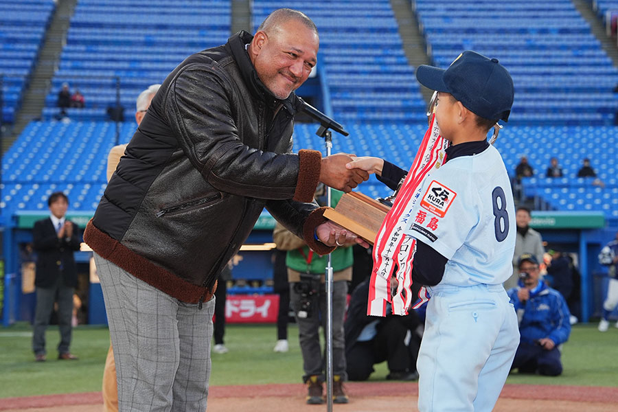 トロフィーを手渡すアレックス・ラミレス氏【写真：小林靖】