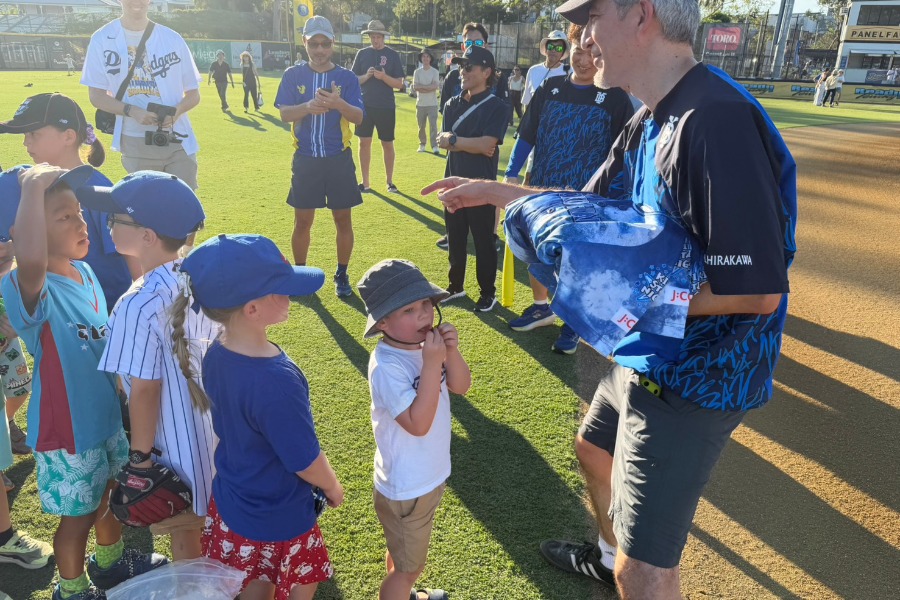 豪州の子どもたちにユニホームを配る様子【写真：球団提供】