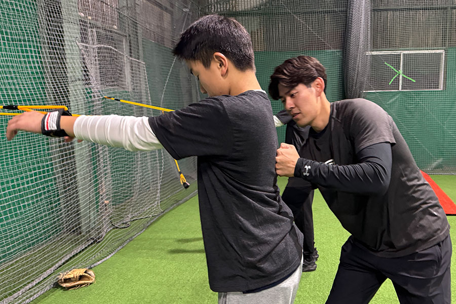 ゴムバンドトレーニングを指導する様子【写真：編集部】