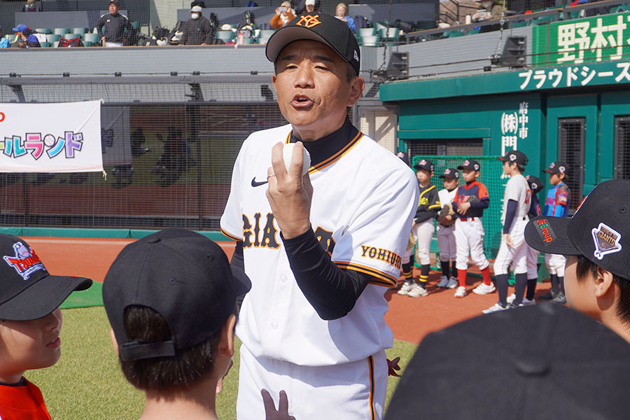 ボールの握り方を実演する前田幸長氏【写真：尾辻剛】