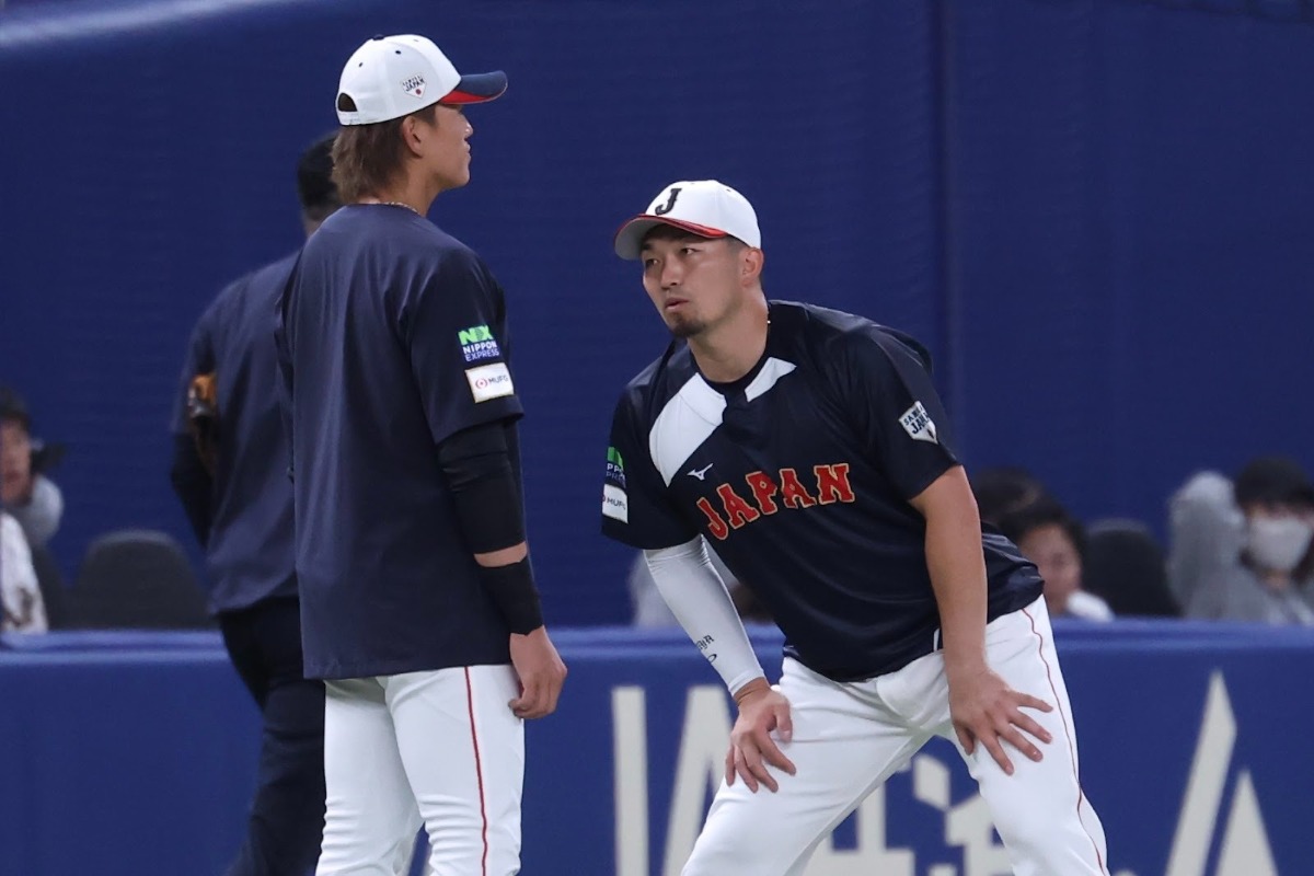28日の試合前、鈴木誠也と会話する山本【写真：加治屋友輝】