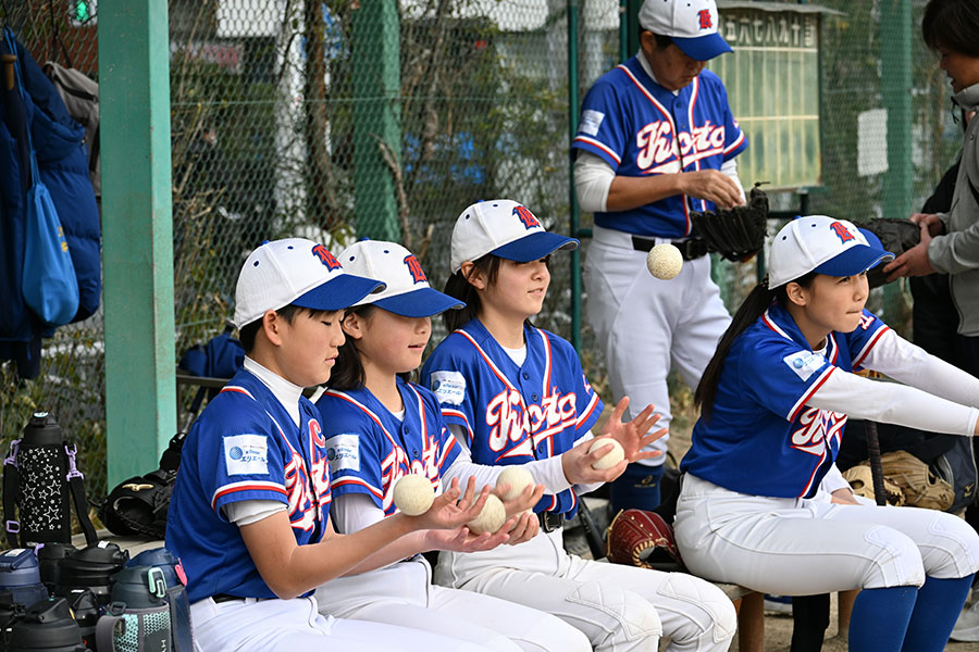 ベンチでリラックスした様子のオール江東女子ナイン【写真：吉田三鈴】