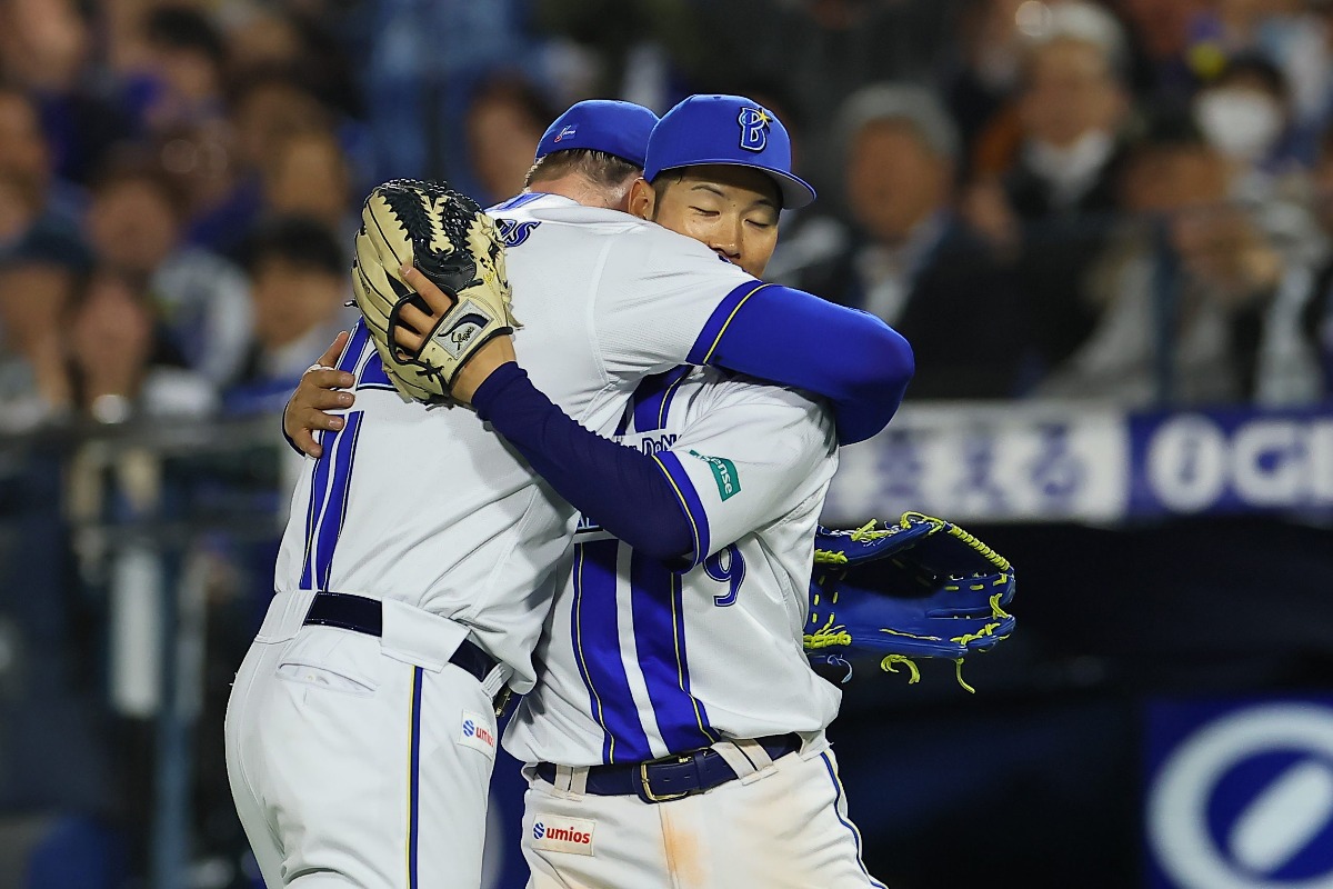 絶対絶命のピンチでスーパーキャッチを見せ、ショーン・レイノルズから抱きしめられるDeNA・京田陽太【写真提供：産経新聞社】