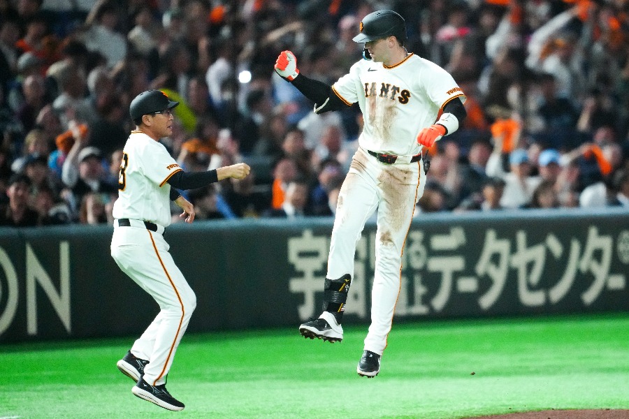 川相昌弘コーチ（左）と跳んでタッチを交わすトレイ・キャベッジ【写真：イワモトアキト】