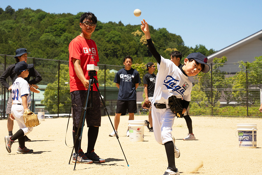 球速計測を行う多賀少年野球クラブの辻正人監督（左）【写真：磯田健太郎】