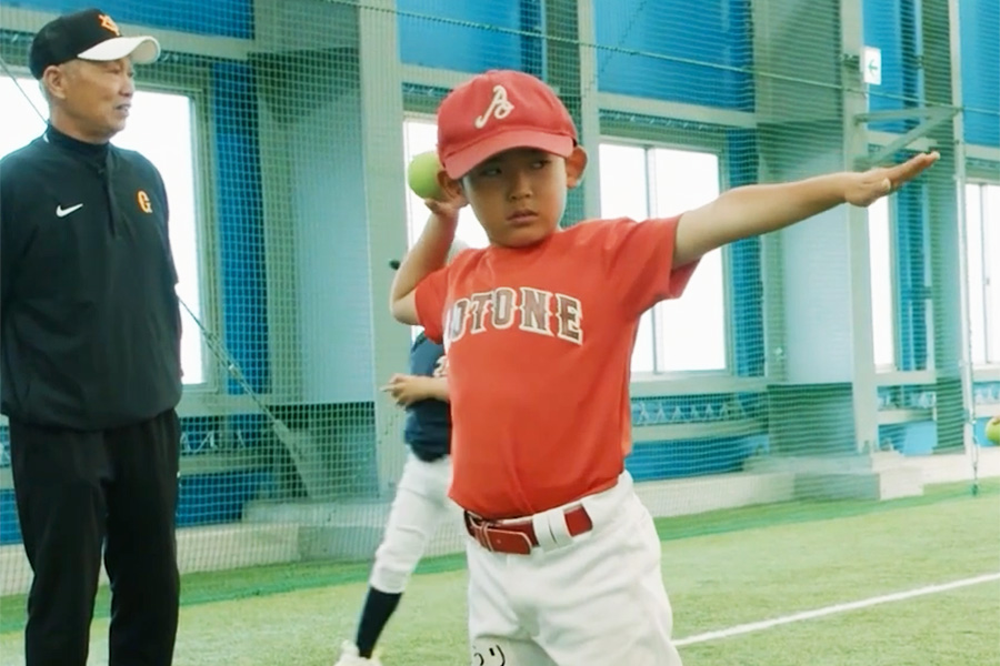 低学年に投げ方を指導する倉俣徹さん（左端）【写真：編集部】